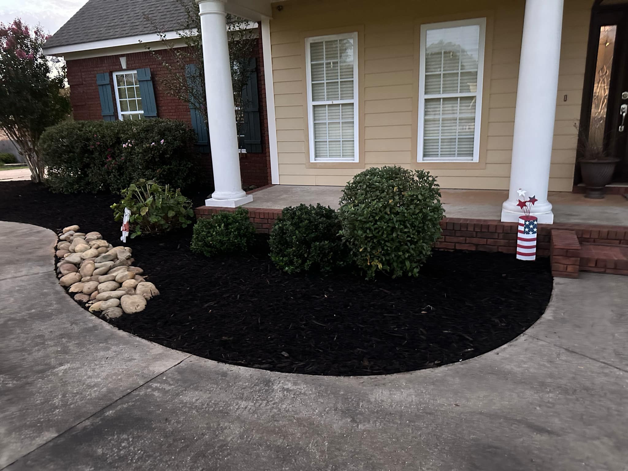 Well maintained garden bed with fresh mulch and neatly trimmed hedges
