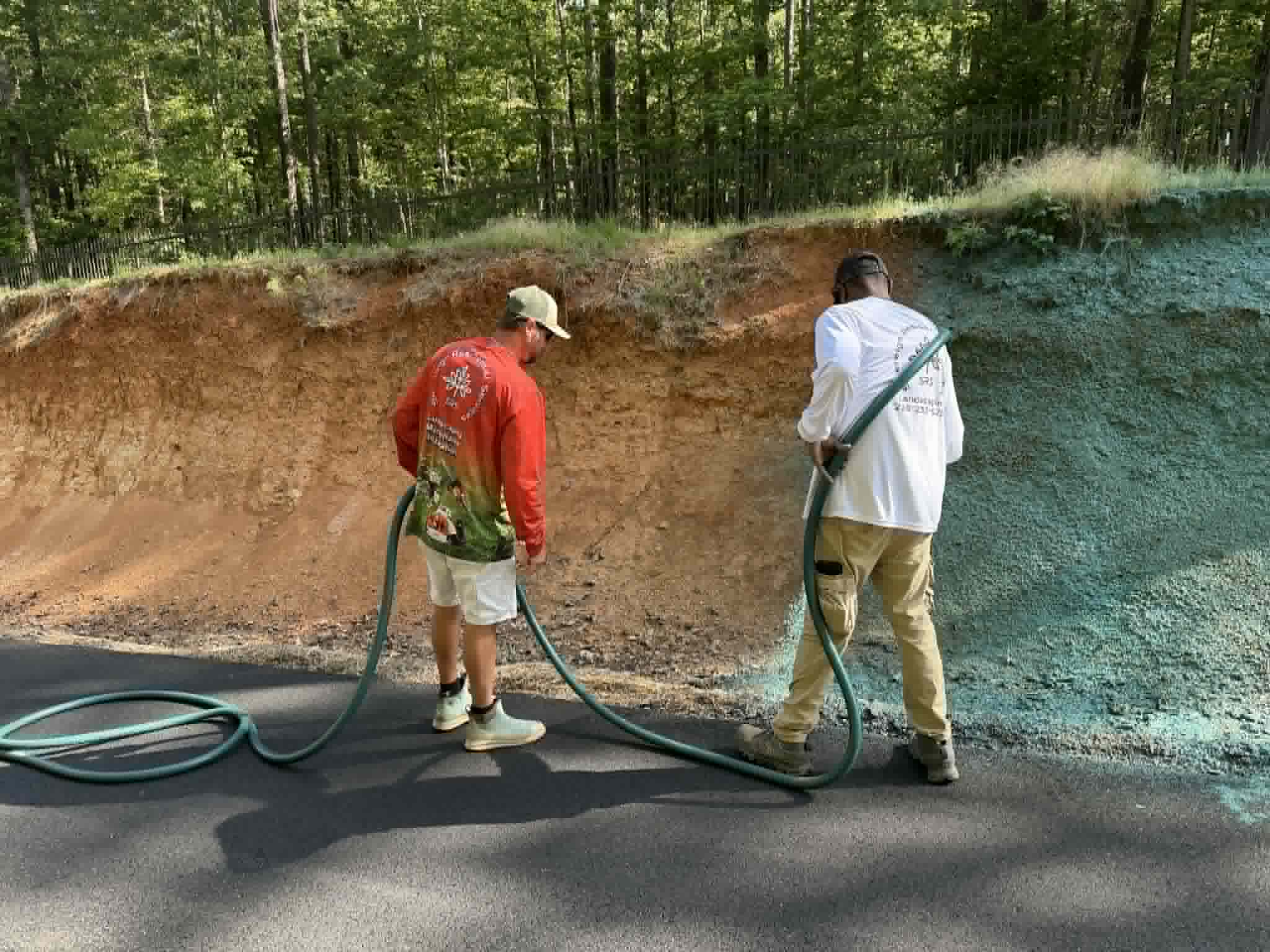 Sovereign Residential crew applying hydro seed on steep embankment